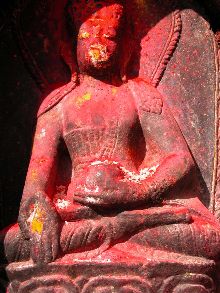 Manaslu 00 09 Kathmandu Boudhanath Statue Closeup Around the base of the Kathmandu�s Boudhanath Stupa�s circular mound are 108 niches, each containing the Dhyani Buddha Akshobhya, with a decidedly Hindu flavour. Akshobhya is blue with his right hand touching the earth while his left hand holds a begging bowl. He is the Buddha of the East and is dedicated to helping you overcome hatred, anger and aversion.